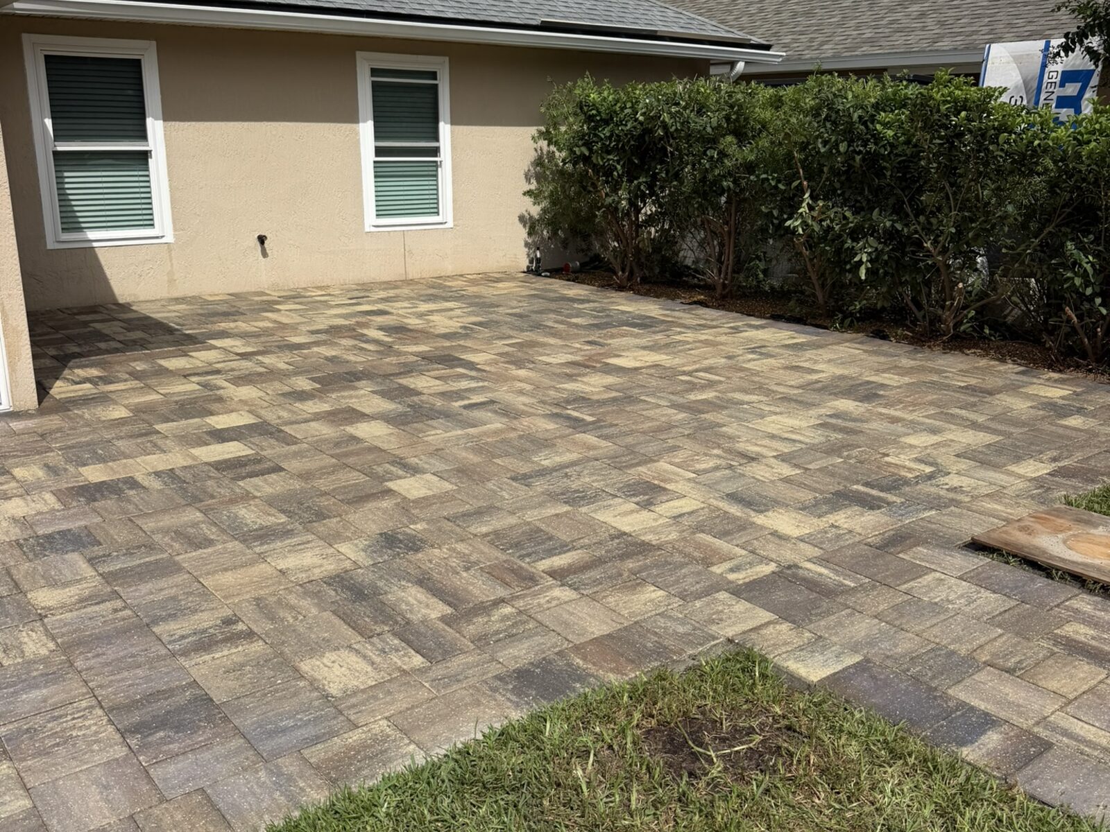 Interlocking paver patio beside a home after cleaning and sealing